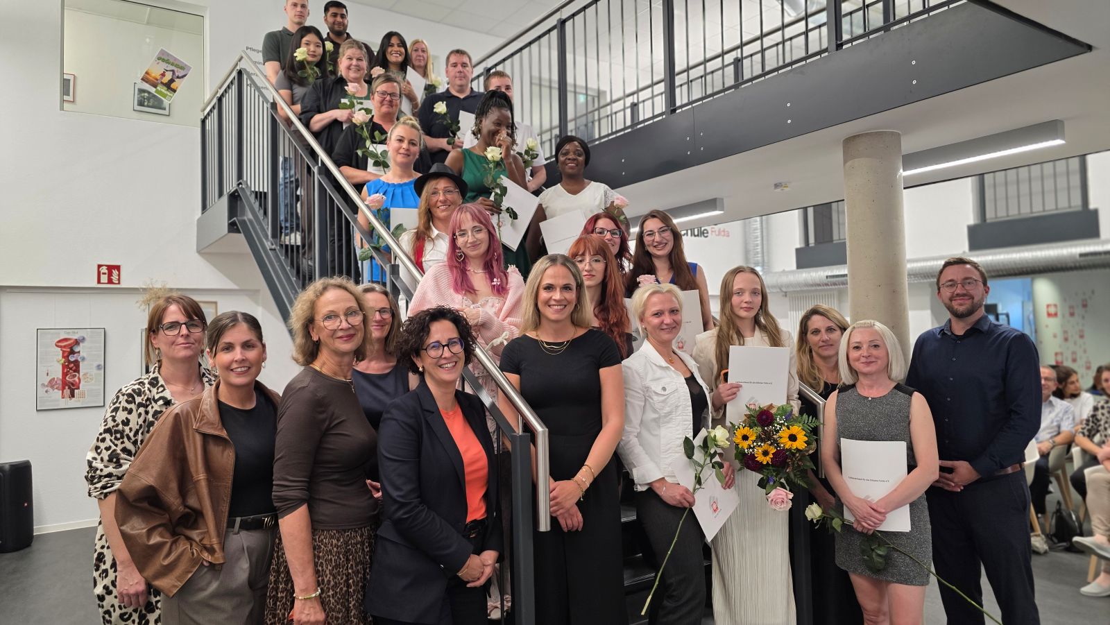 Gruppenbild mit dem Team der Caritas-Pflegeschule und 21 neuen Altenpflegehilfskräften.