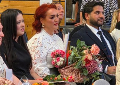 Absolventen im Publikum mit Blumen